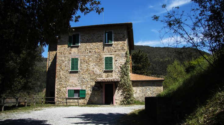 Ein historisches Gebäude auf dem Land, das in ein gemütliches Hotel umgewandelt wurde, umgeben von grünen Wiesen.
