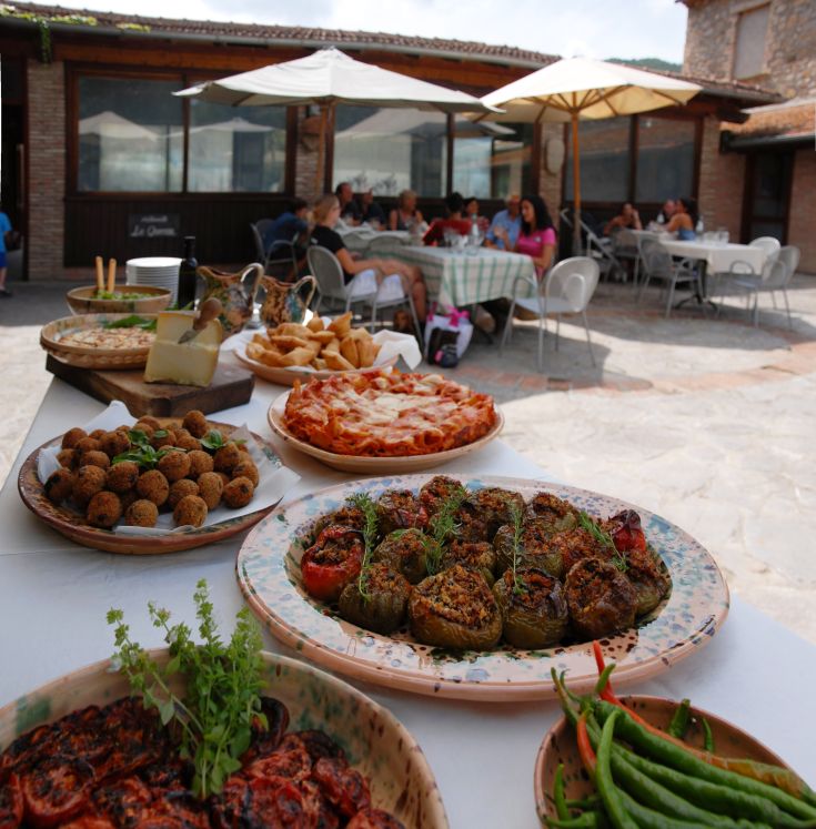 Ein Tisch im Freien mit regionalem Essen in einer einladenden Atmosphäre.