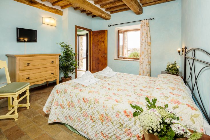 A simple room with floral decorations and a view of nature. Perfect for a peaceful stay.