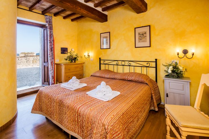 Elegant room with a double bed and views of the surrounding nature. Cozy rustic furnishings.