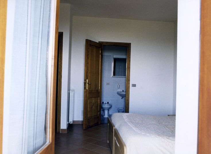 Une chambre à coucher simple et fonctionnelle avec une salle de bain à l'arrière.