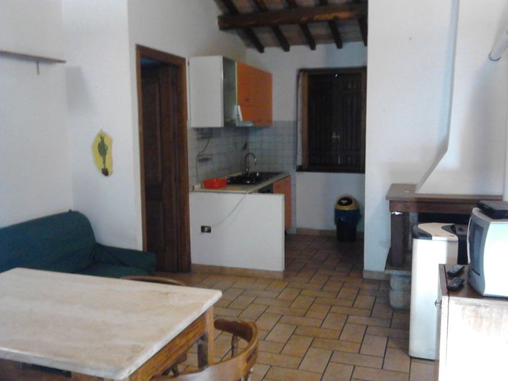 Intérieur d'un bâtiment avec cuisine et salon, aménagé de manière fonctionnelle et sobre.