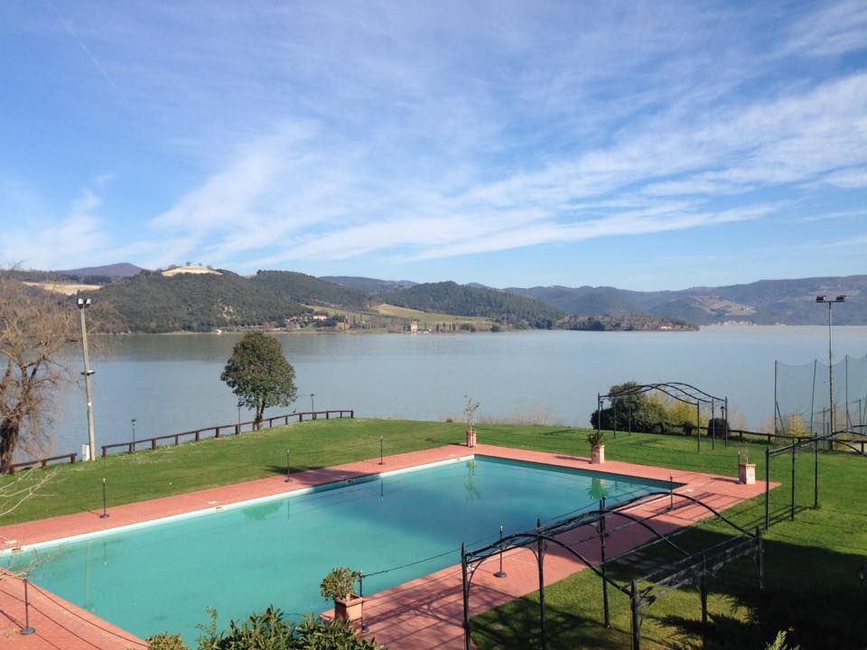 Vue d'un lac entouré de collines, avec une piscine au premier plan.