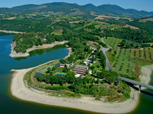 Scena di un albergo circondato da vegetazione, con piscine e spazi verdi che creano un ambiente rilassante.