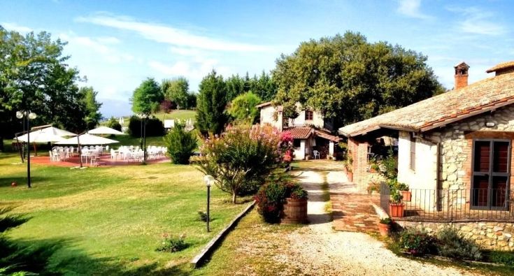 Un panorama di un'accogliente struttura circondata da un verde lussureggiante, con aree all'aperto per eventi.