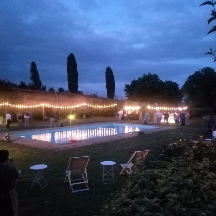 Ein Garten mit sanft beleuchtetem Pool an einem ruhigen Abend.