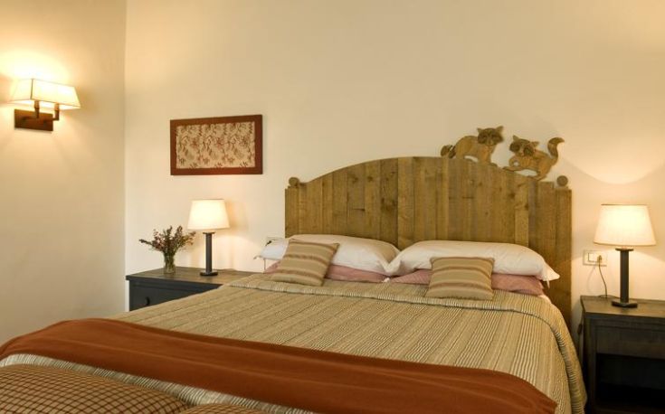 Ein einfaches Zimmer mit einem Holzbett und dezenten Dekorationen für eine gemütliche Atmosphäre.