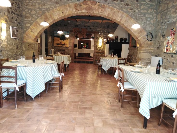 Innenansicht eines Restaurants mit dekorierten Tischen und einer warmen, einladenden Atmosphäre.