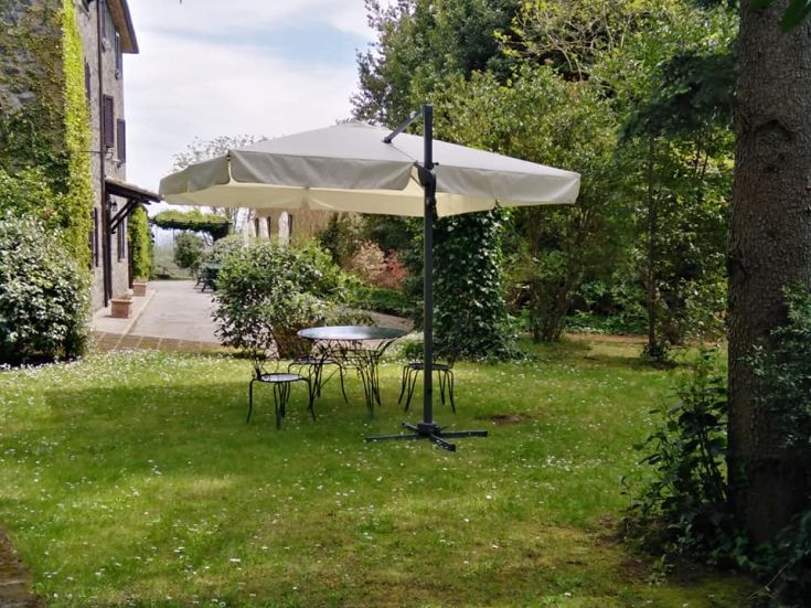 Ein gemütlicher Garten mit einem Tisch und einem Sonnenschirm, perfekt zum Entspannen im Freien.