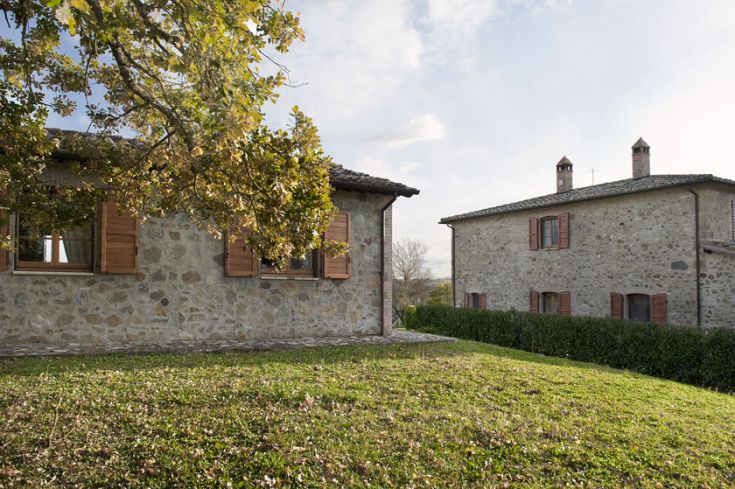 Historic restored estate surrounded by vast green spaces in the natural landscape of Umbria.