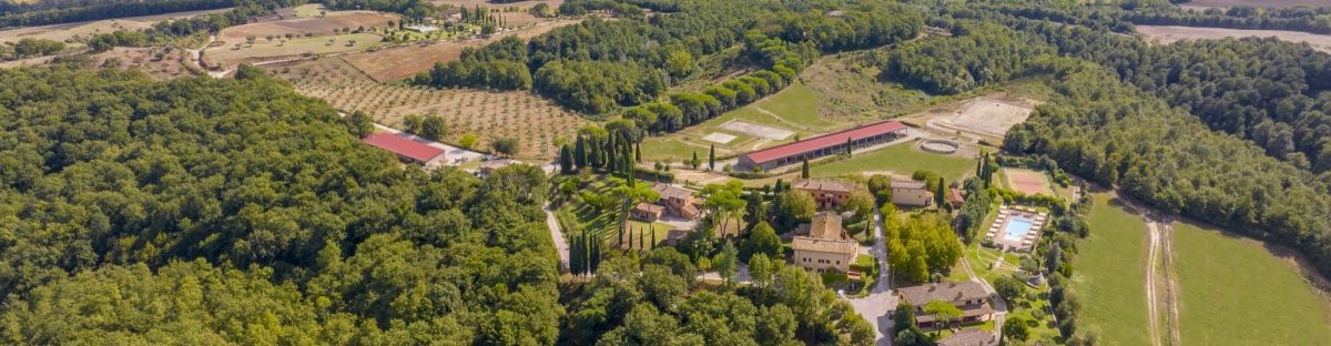 Un domaine historique entouré de verdure luxuriante, avec des bâtiments et des jardins privés.