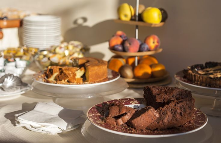 Selezione di dolci e frutta disposti su un tavolo, perfetta per una colazione abbondante.