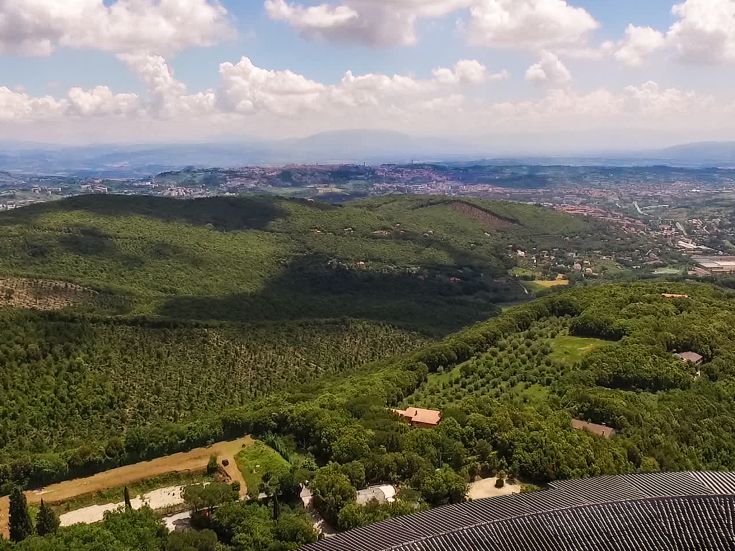Scena delle colline umbre, caratterizzate da vegetazione verdeggianti e un cielo finemente nuvoloso.
