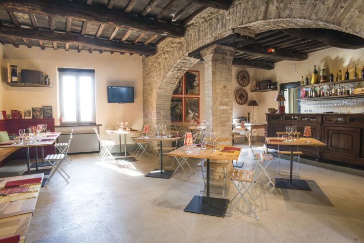 Rustic restaurant with simple wooden furniture and stone walls, perfect for relaxed lunches and dinners.