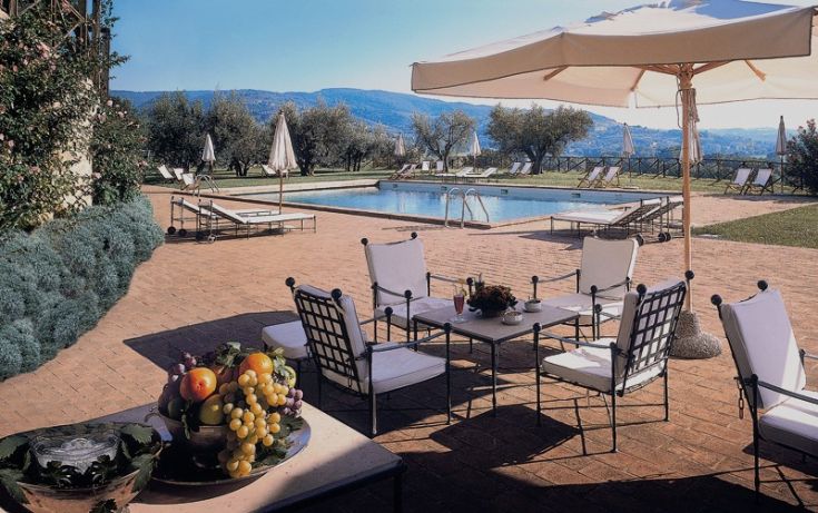 Pool in a serene area, surrounded by lounge zones and characteristic Umbrian landscapes.