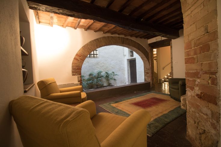 Cozy corner with chairs and wooden beams, overlooking an inner courtyard.