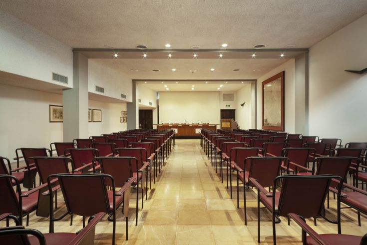Simple conference room with rows of chairs, suitable for events and meetings.