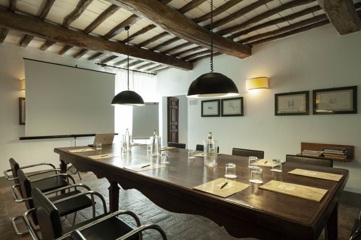 A meeting space with a wooden table, designed for events and gatherings in a cozy atmosphere.