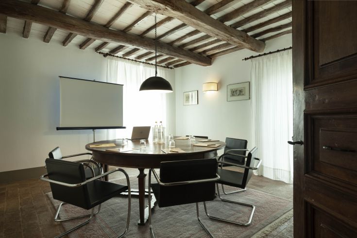 Comfortable meeting space with a round table and chairs, featuring natural light for a relaxed atmosphere.