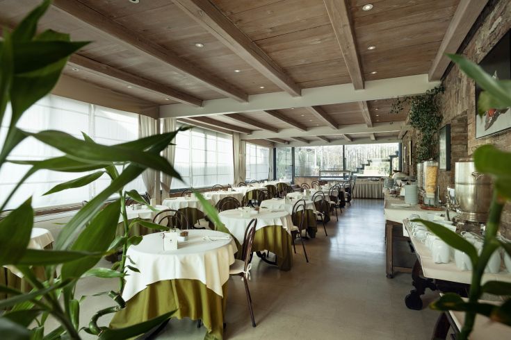 A simple yet elegant atmosphere in an Umbrian restaurant, featuring tidy tables and a pleasant view.