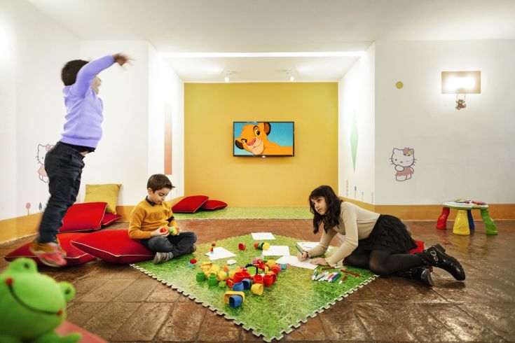 A cheerful nursery with children engaged in play activities, surrounded by bright colors and toys.