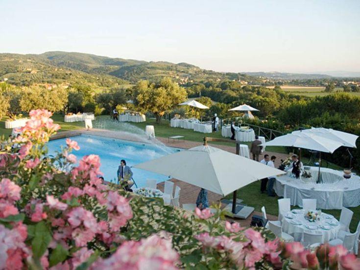 A pool set in a natural landscape, surrounded by simple decorations for an outdoor event among gentle hills.