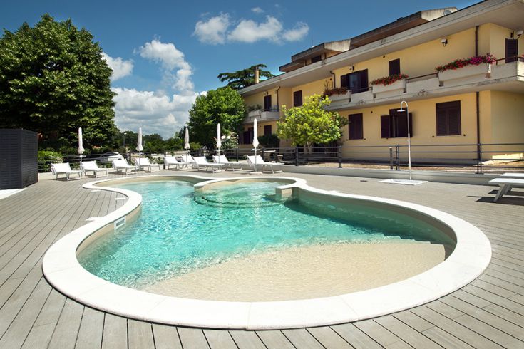 Una piscina piacevole circondata da lettini in un contesto esterno gradevole.