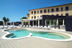 Area piscina semplice con lettini, immersa in un ambiente tranquillo e cielo sereno.