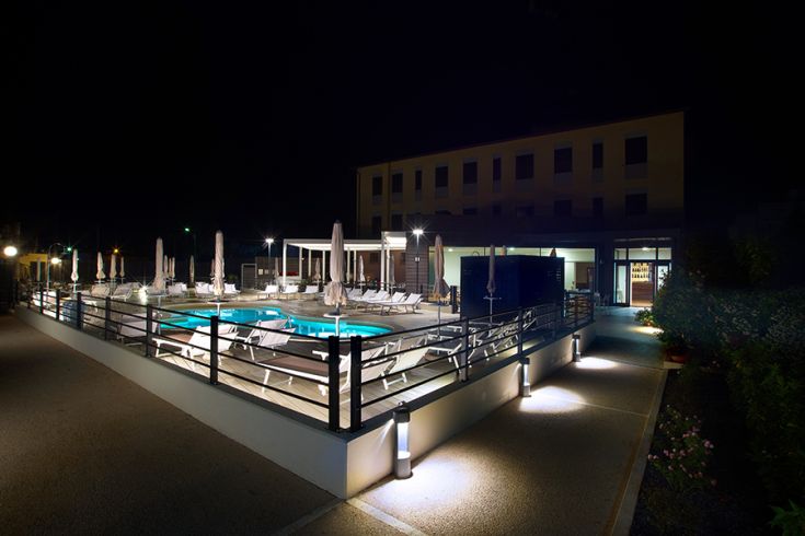 Panorama notturno della piscina di un hotel, illuminata da luci delicate.