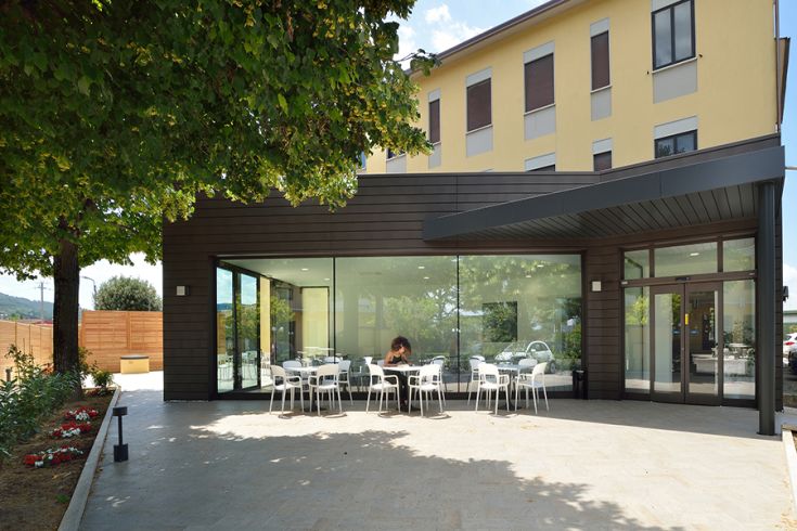 Una facciata semplice di un hotel con una terrazza all'aperto, luogo di relax per gli ospiti.