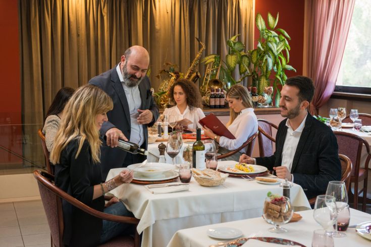 Ein stilvolles Restaurant mit kunstvoll gedeckten Tischen, während das Personal die Gäste bedient.