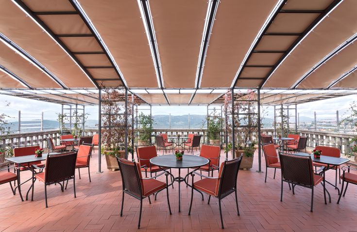 Terrazza con tavoli, affacciata su un panorama della valle Umbra, ideale per momenti di relax.