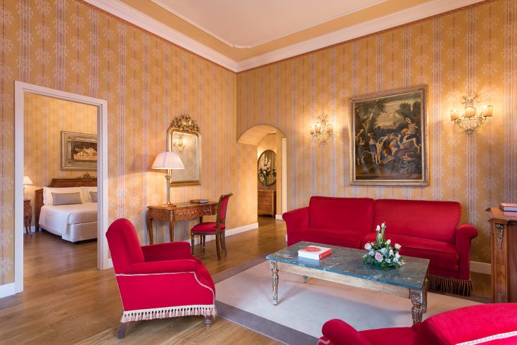 Un soggiorno con arredi rossi e particolari curati all'interno di un edificio storico.