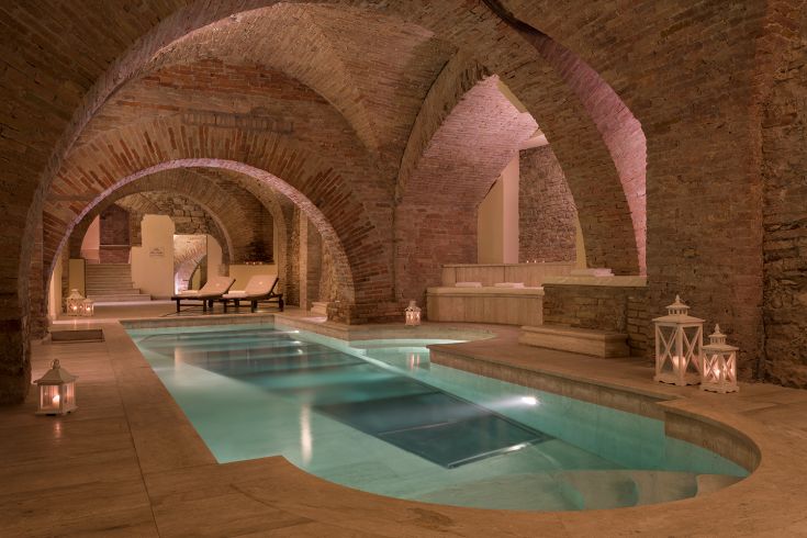 Spa ampia e accogliente con piscina riscaldata, architettura tipica in mattoni e un'atmosfera serena.