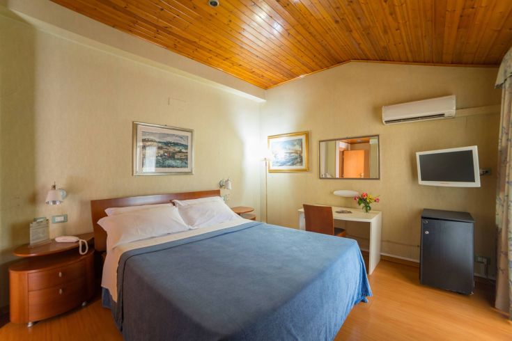 Simple hotel room with a double bed and contemporary furnishings.