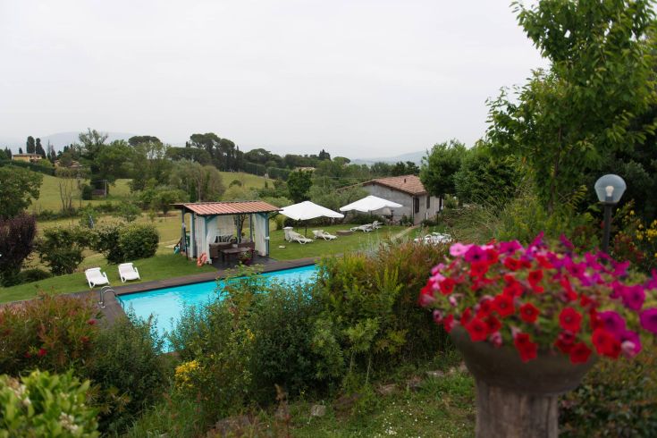 Hotel Montebello, nestled in greenery with a pool, located in a hilly area near Perugia.