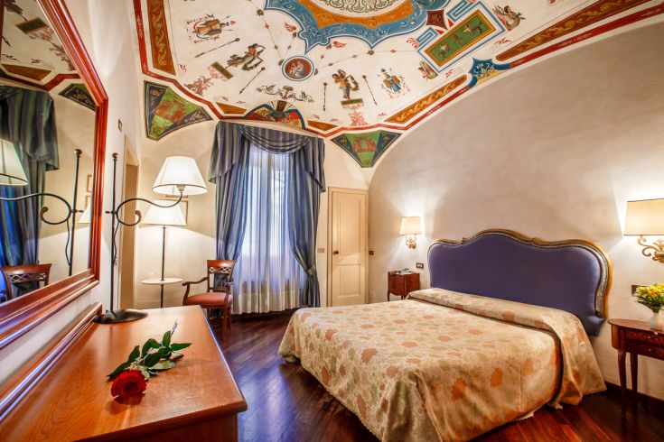 Hotel room with a decorated ceiling, providing a comfortable and welcoming atmosphere for guests.
