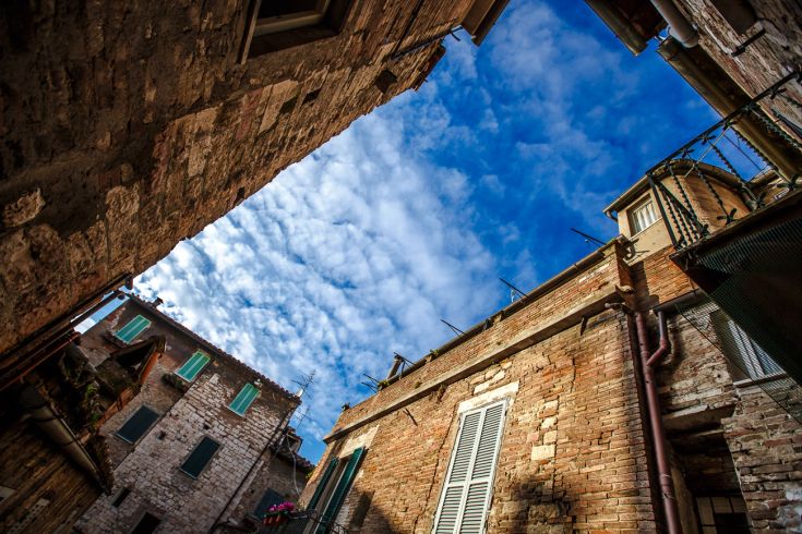 A glimpse of sky visible between brick buildings, showcasing the city's historic atmosphere.