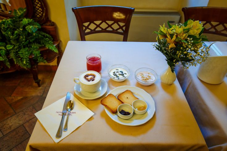 Breakfast in a cozy atmosphere at Hotel Fortuna, with coffee, yogurt, toast, and seasonal fruits.