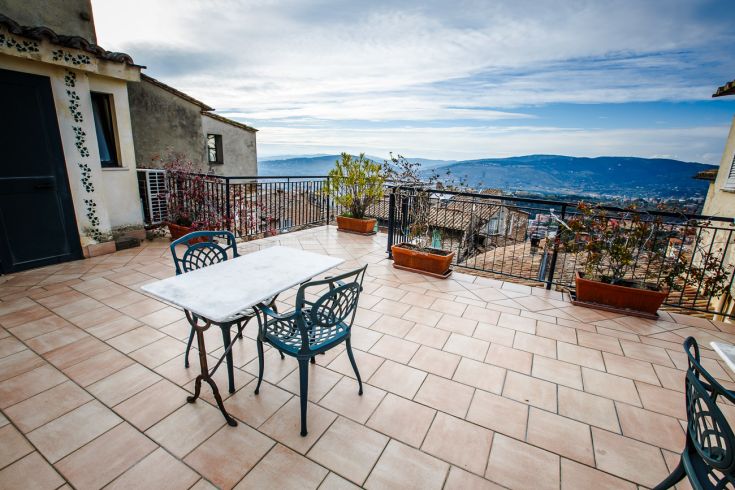 A terrace with a view of the surrounding landscape, featuring simple furniture and a relaxed atmosphere.