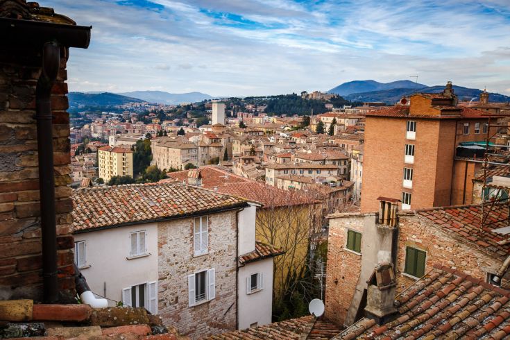 A landscape view of a residential area with red-tiled roofs and hills in the background, a typical scenic sight.