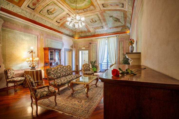 Elegant interior space with period frescoes and classy furniture, perfect for moments of quiet relaxation.