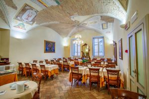 Interior of a restaurant with a decorated ceiling and neatly arranged tables.