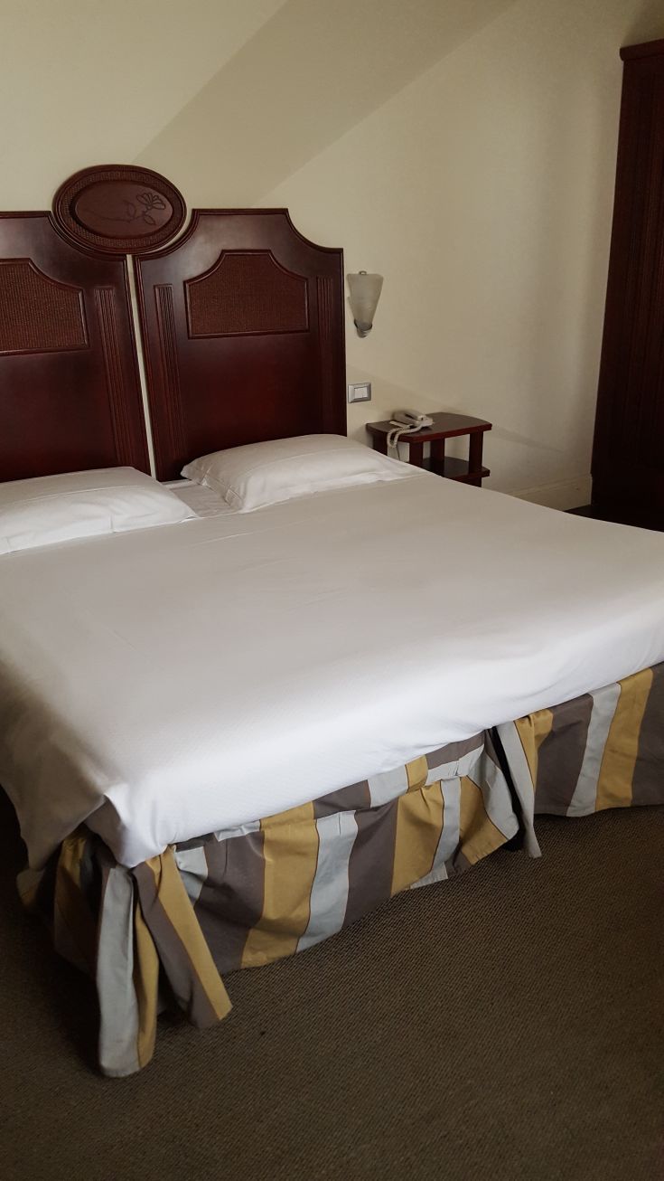 Camera semplice con letto matrimoniale e arredamento tradizionale, adatta per un soggiorno tranquillo.