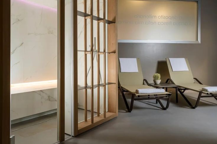 Area benessere attrezzata con lettini e finiture curate, ideale per un momento di relax.