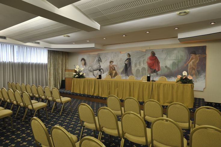 A simple and functional event space with neatly arranged chairs and minimal decorations in the background.