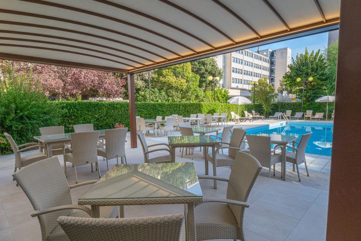 An outdoor space with a pool and tables, perfect for relaxation and leisure.