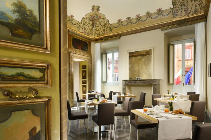 Breakfast area with traditional decor and historical frescoes, located in the Hotel della Posta in Perugia.