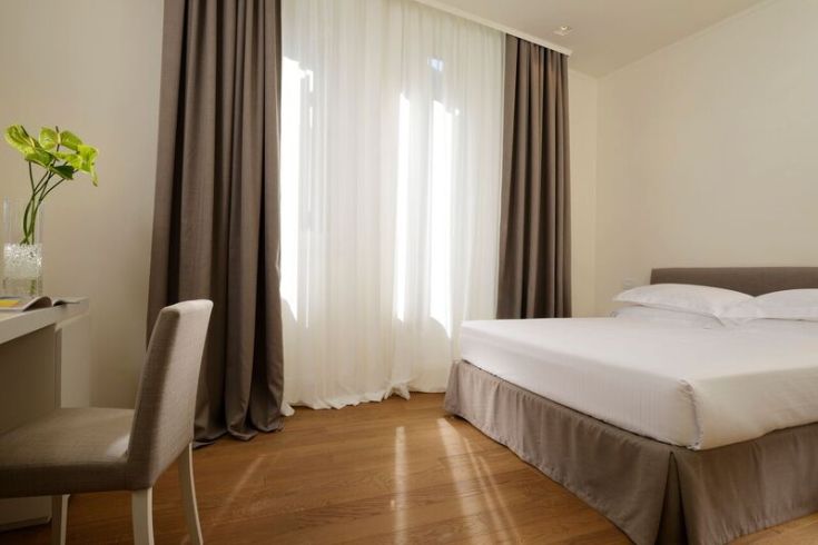 Simple hotel room with natural light and minimalistic decor.