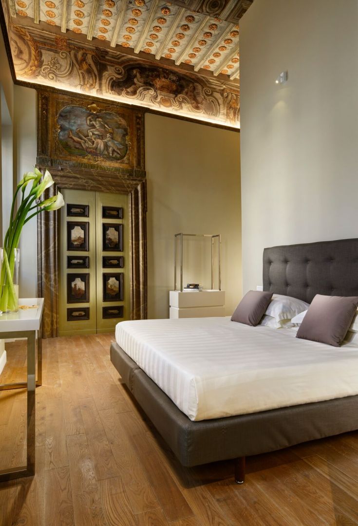 Cozy hotel room with historic decor and contemporary furniture in an Umbrian boutique hotel.